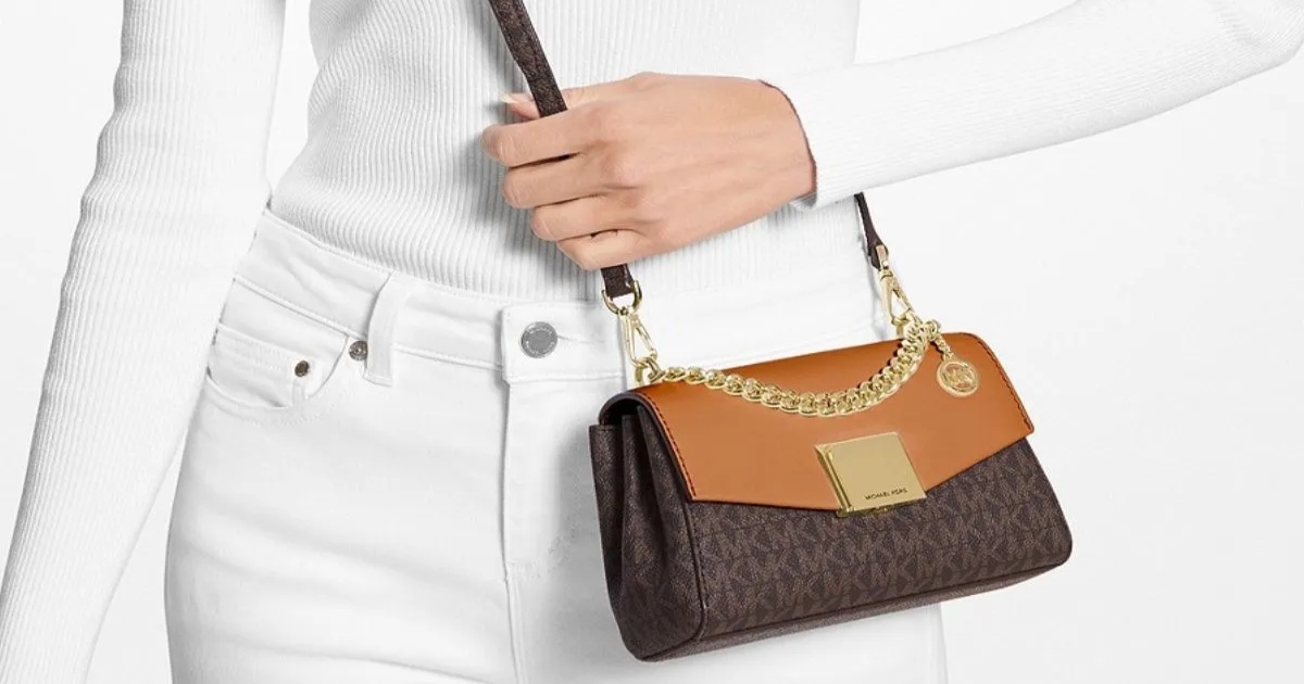 brown Michael Kors crossbody worn by a woman wearing all white