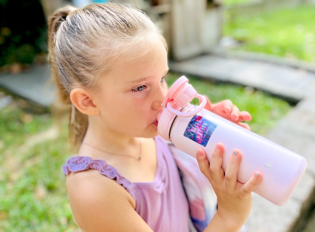 girl sipping from pink water bottle