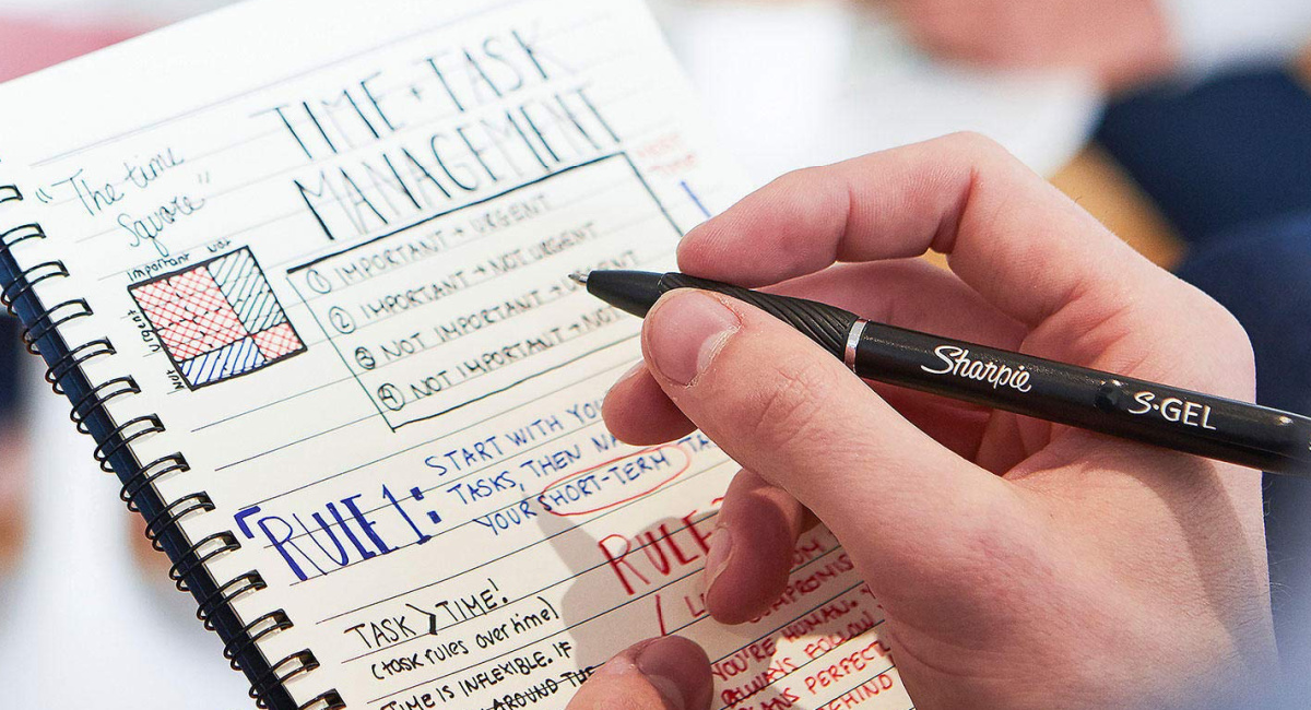person writing using sharpie pen