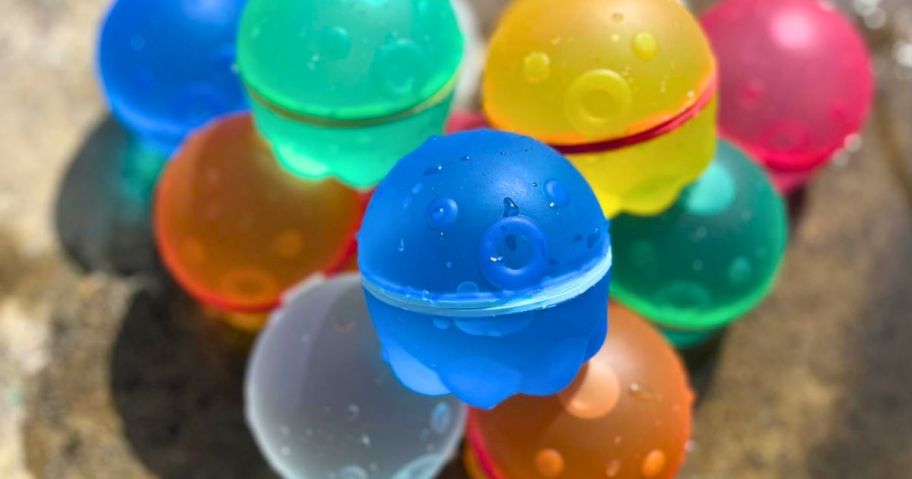 squid face reusable water balloons in a colorful pile on a picnic table