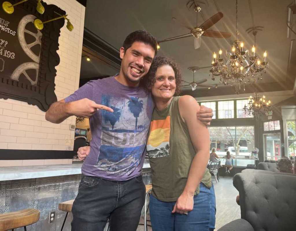 man and woman posing for picture in coffee shop