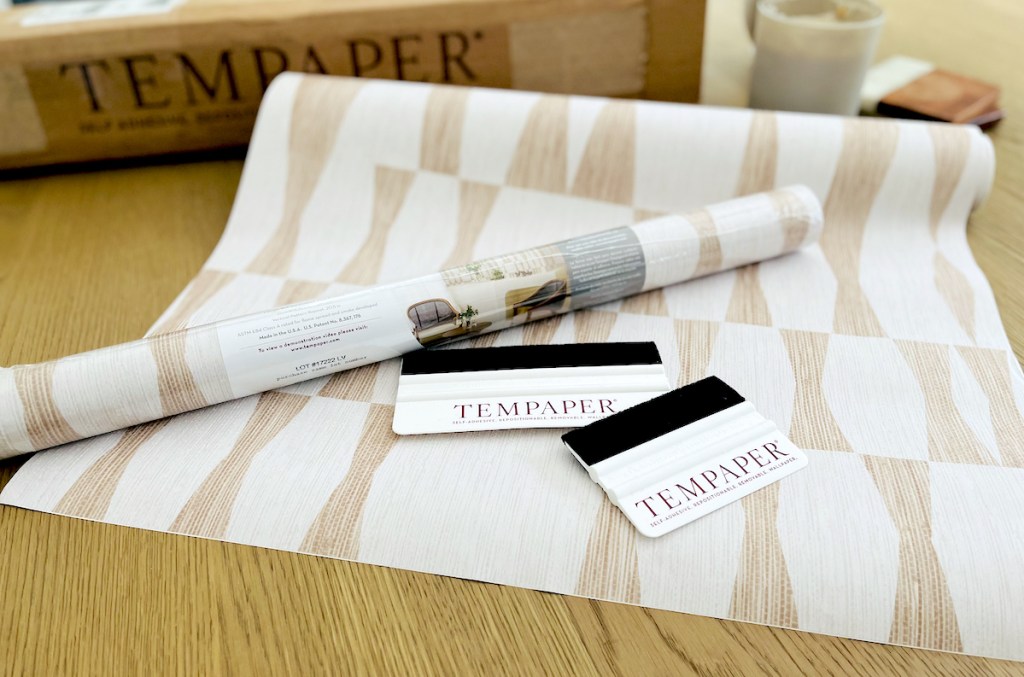 tempaper peel and stick wallpaper rolls and applicators sitting on wood table