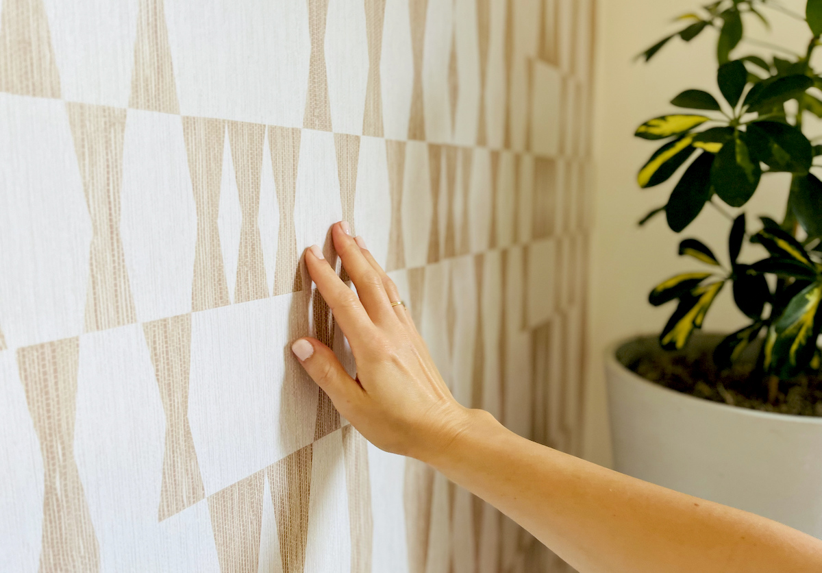 hand touching patterned texture peel and stick wallpaper