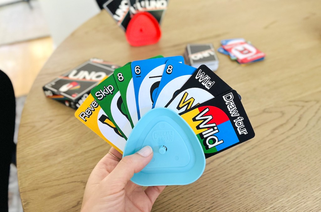 hand holding blue card holder with uno classic board game