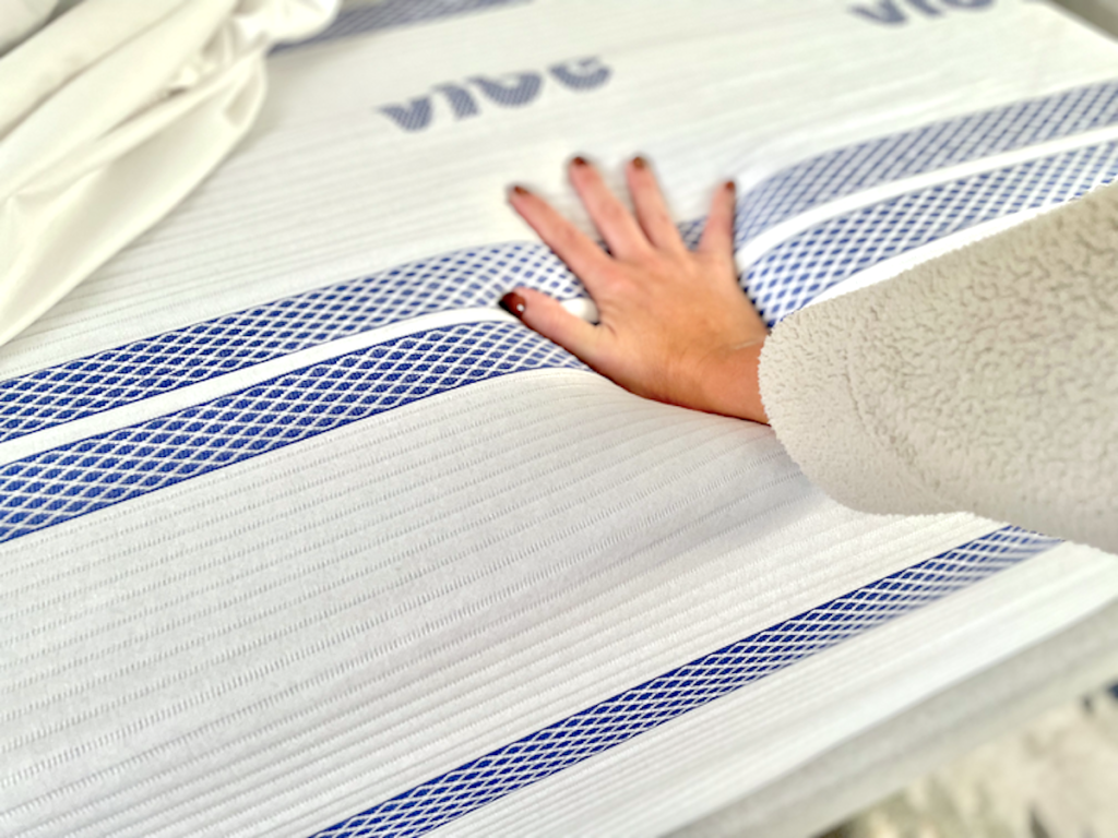 hand pushing down on vibe mattress