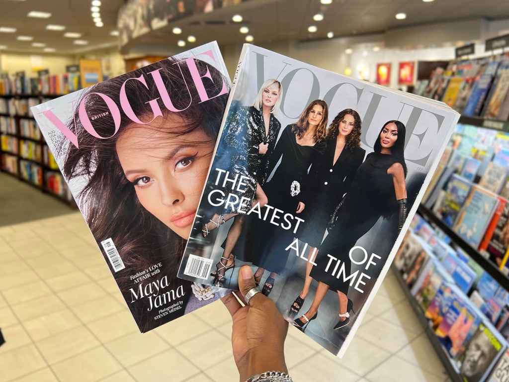 hand holding two vogue magazines