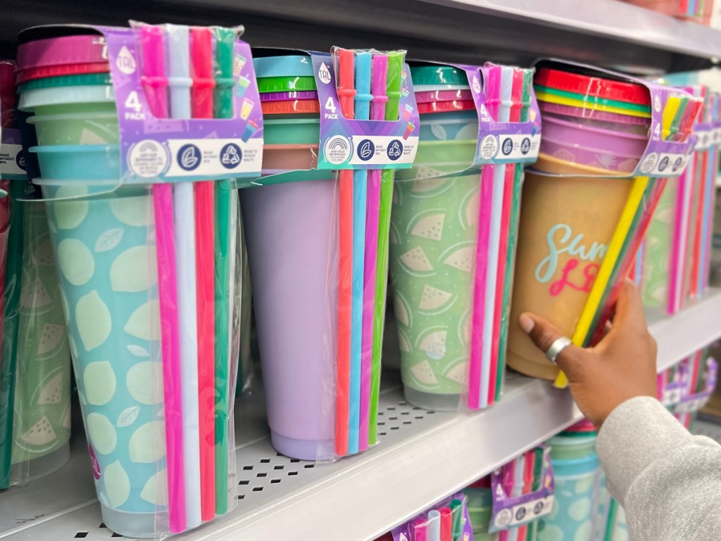 4 packs of color changing cups on shelf with woman taking one off shelf in walmart