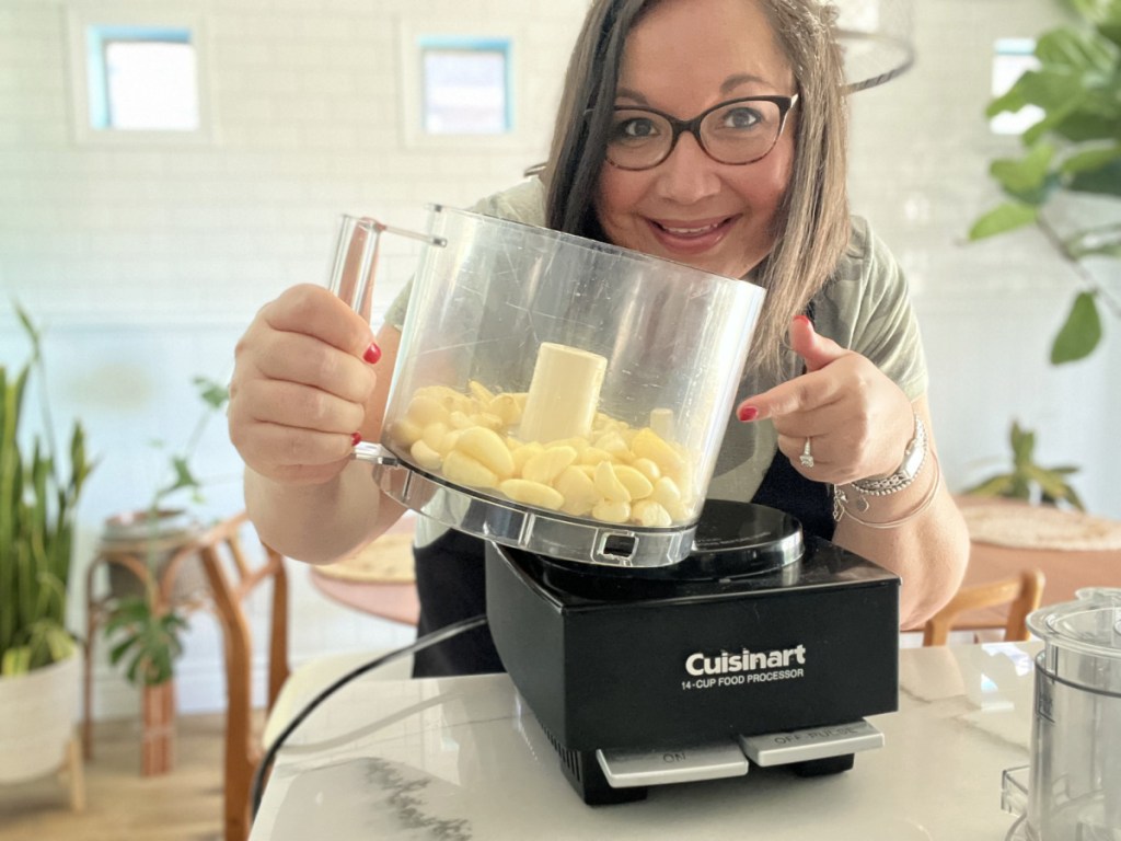 woman with whole garlic cloves in a food processor