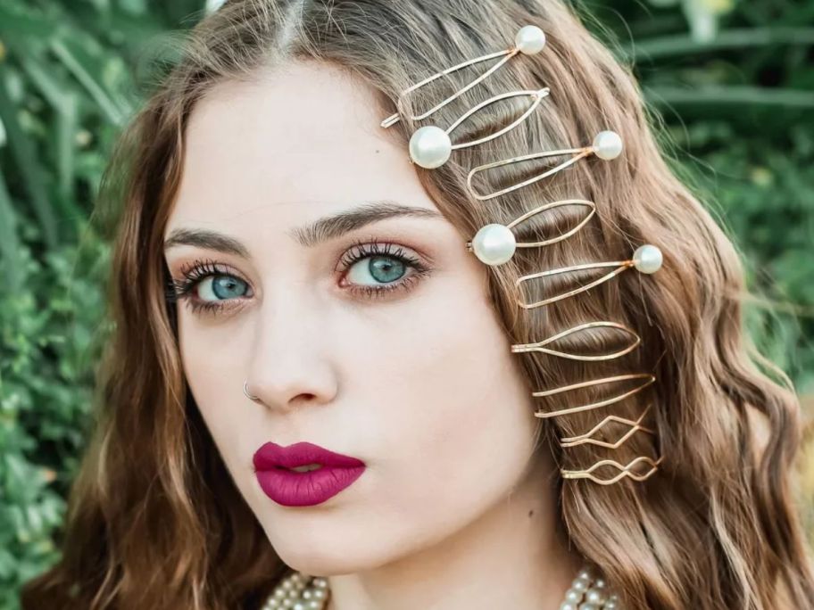 woman with various gold and pearl large hair clip bobby pins in her hair