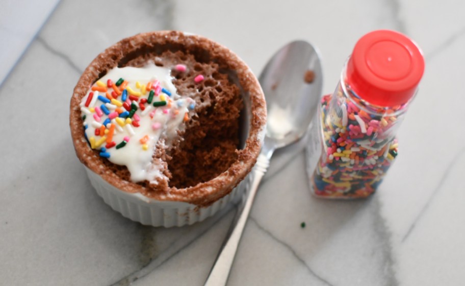 A 321 Mug Cake with sprinkles and a spoon