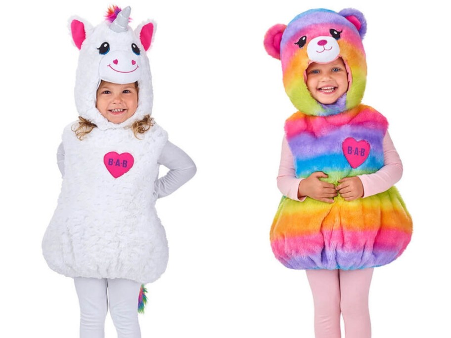 little girls wearing a white Unicorn Halloween Costume and a rainbow Build a Bear Costume