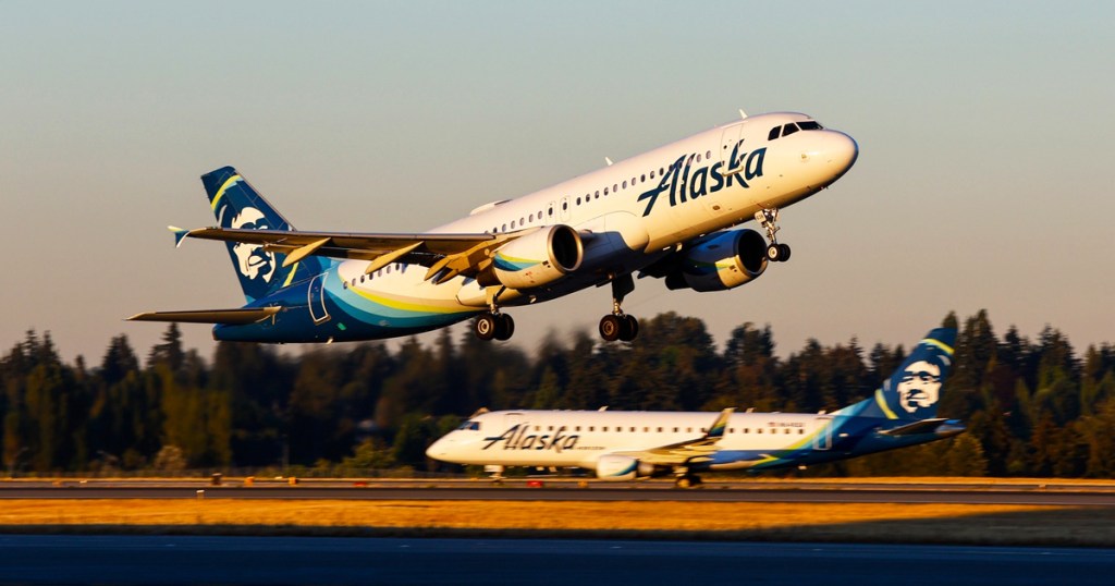 two alaska air planes arriving and departing