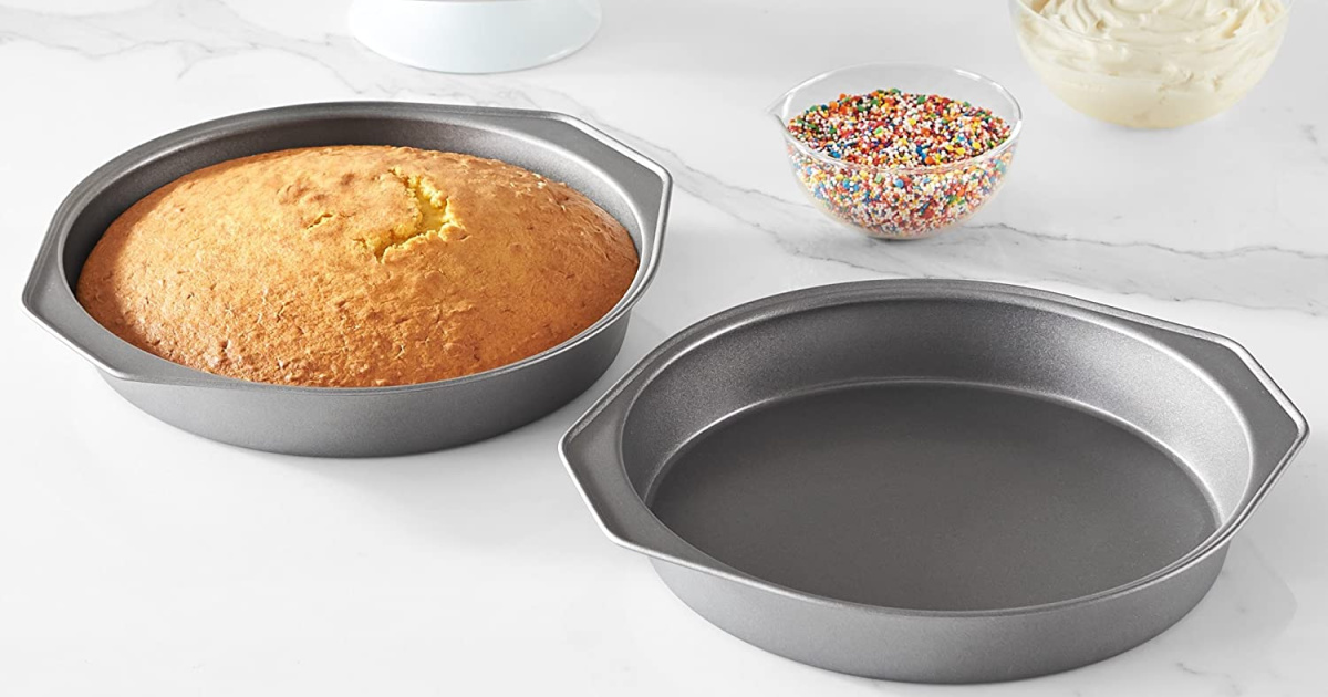 tow cake pans, one with cake layer, on marble surface