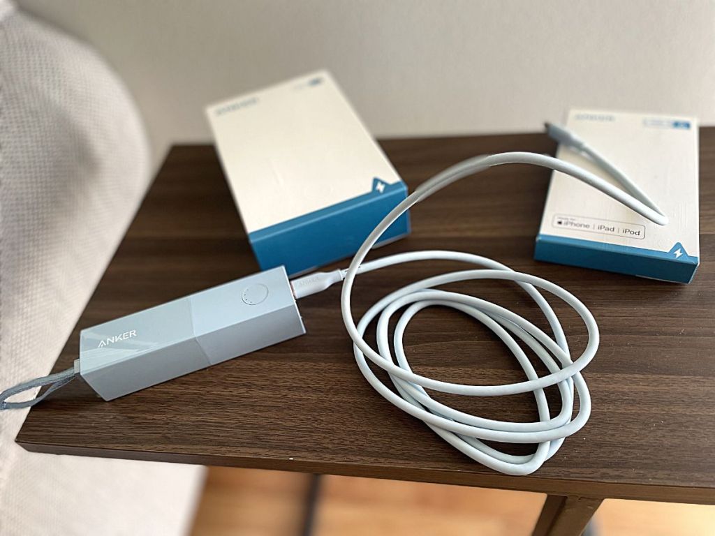 Anker power bank and cable on side table
