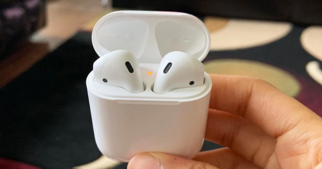 hands holding airpods in charing case