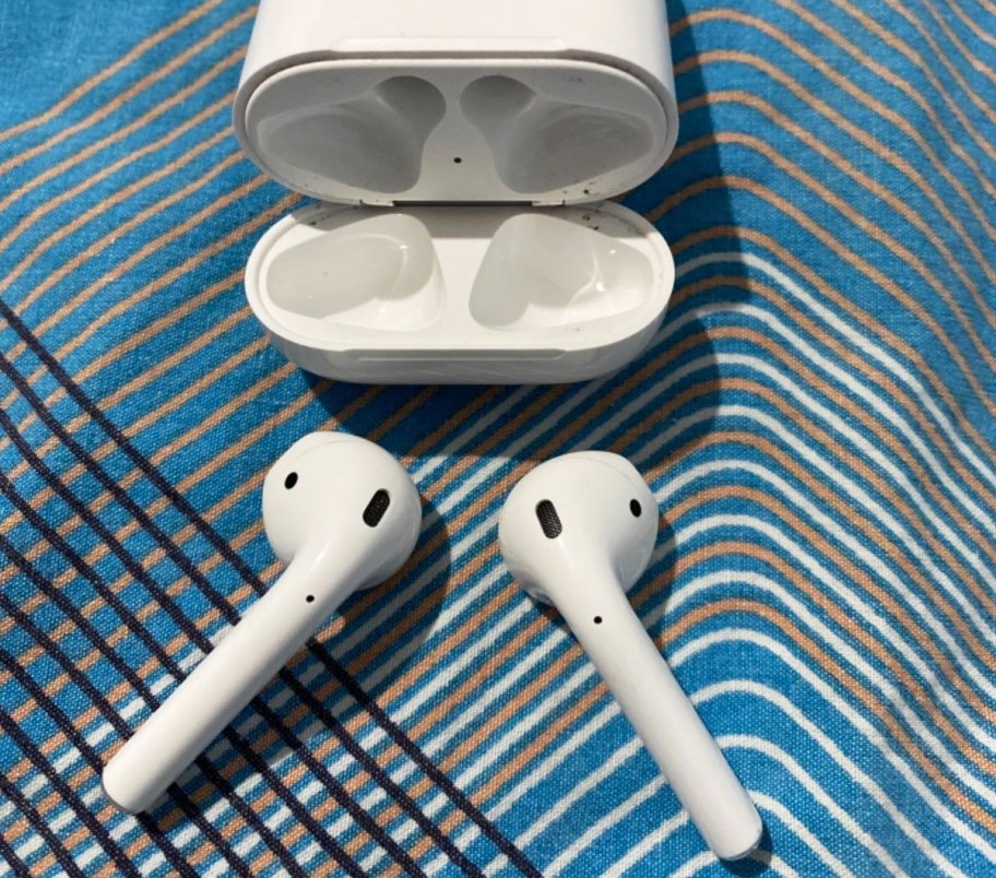 apple airpods next to charging case