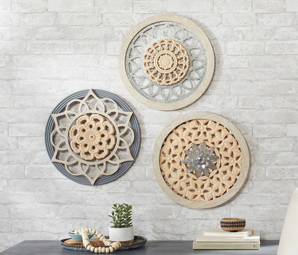 Three circle architectural wall decor pieces hanging on a wall