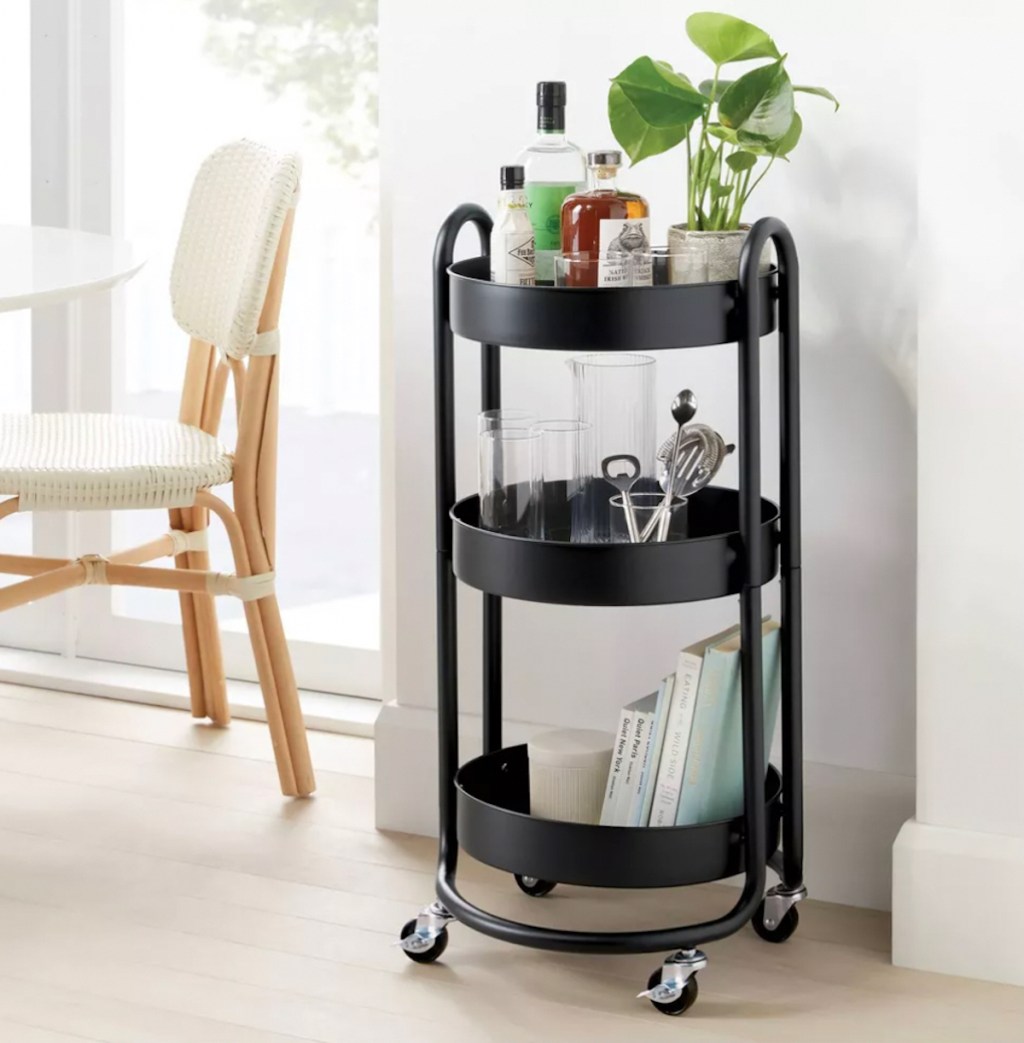 round black metal three tier cart with bar stuff on each level