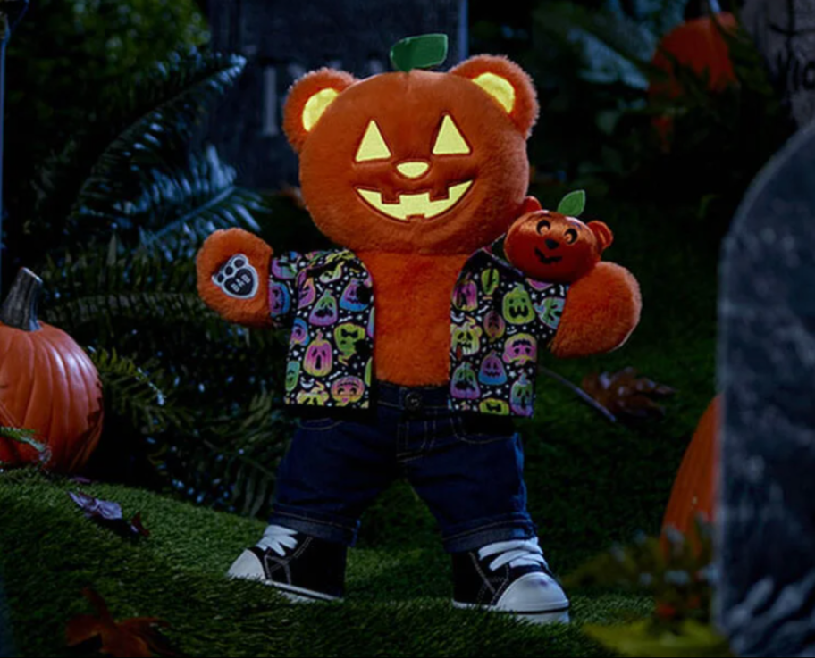 The Build A Bear Halloween Glow Teddy in a neon glow in the dark outfit