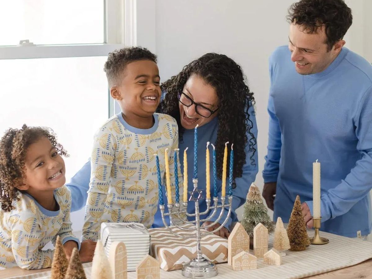 A family of 4 wearing matching Hanukkah pajamas 