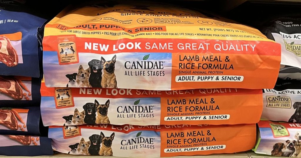 Bags of Canidae Dry Dog food laying flat and stacked on top of one another on a store shelf
