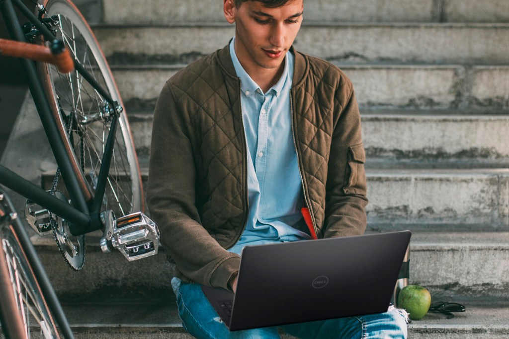 College student working on Dell Laptop looking for jobs at companies that pay for college