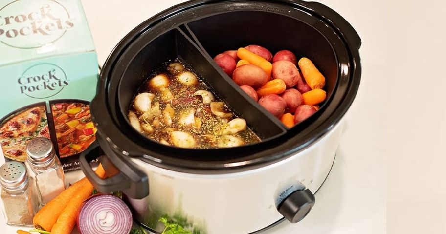 slow cooker with crock pocket inserts showing roast on one side and potatoes and carrots on the other