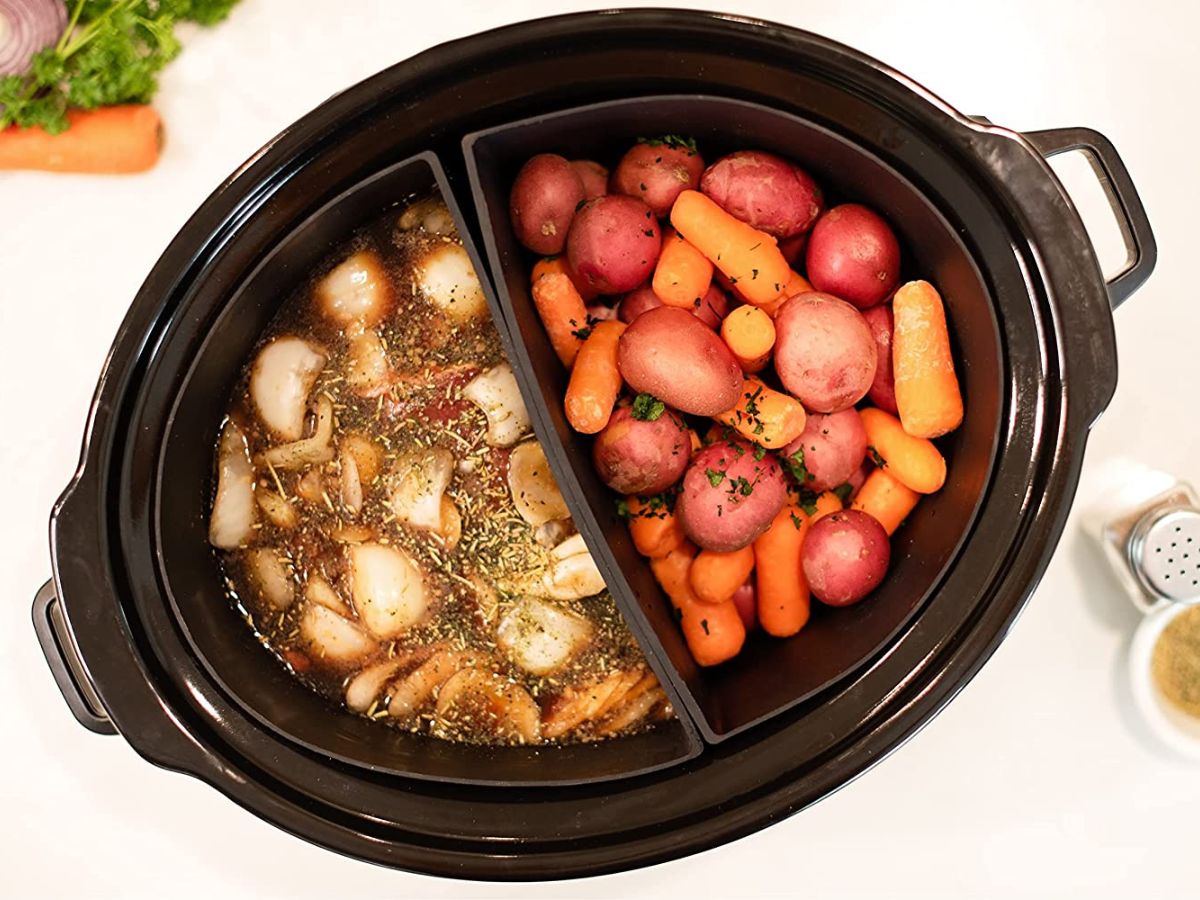 crock pocket slow cooker inserts in a slow cooker filled with potatoes and carrots on one side nad mushrooms and seasonings on the other