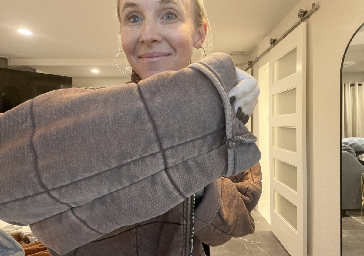 woman holding up sleeve of quilted jacket