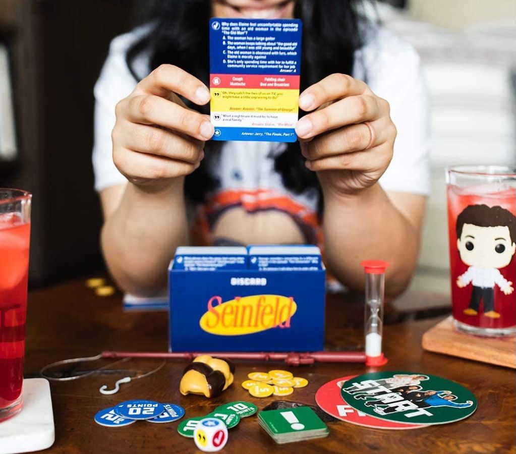Girl showing card from the Funko Seinfeld Game