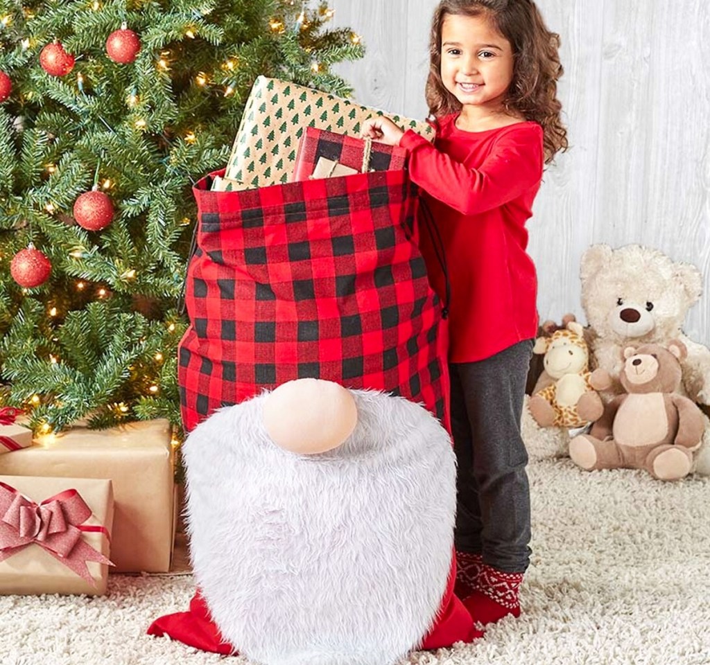 girl next to large gnome gift sack