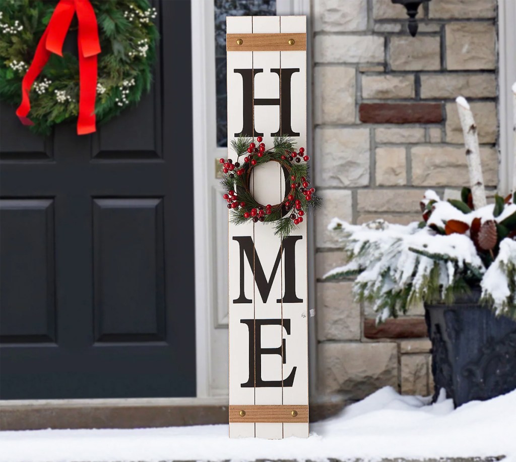 "home" sign in snow with christmas wreath as the letter O