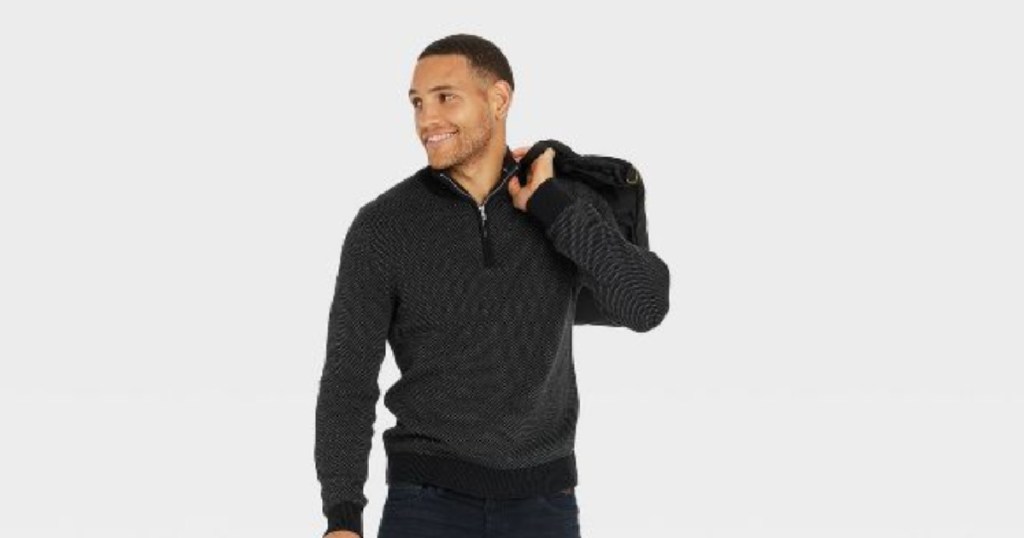 man in gray sweater holding bag