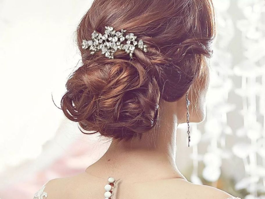 woman in bridal dress showing back of her head with hair styled and fancy wide hair pin 