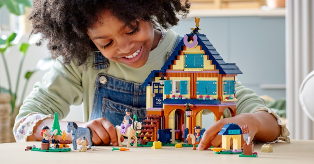 girl playing with ranch and stable playset