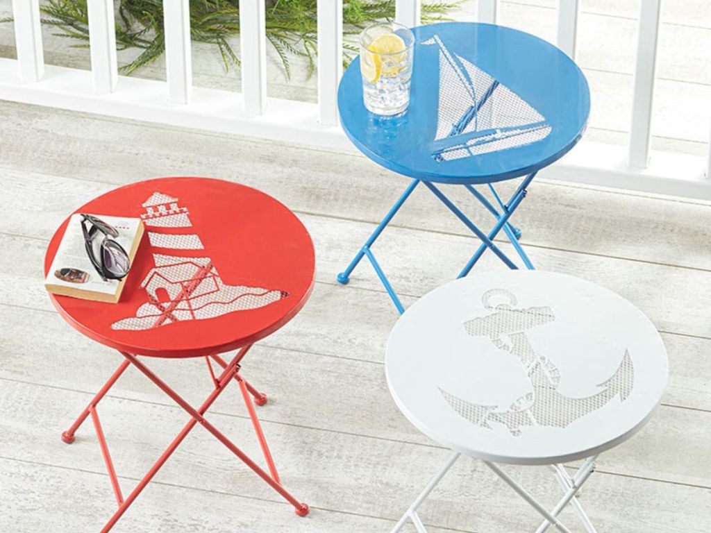 Red, blue, and white patio tables sitting on a deck