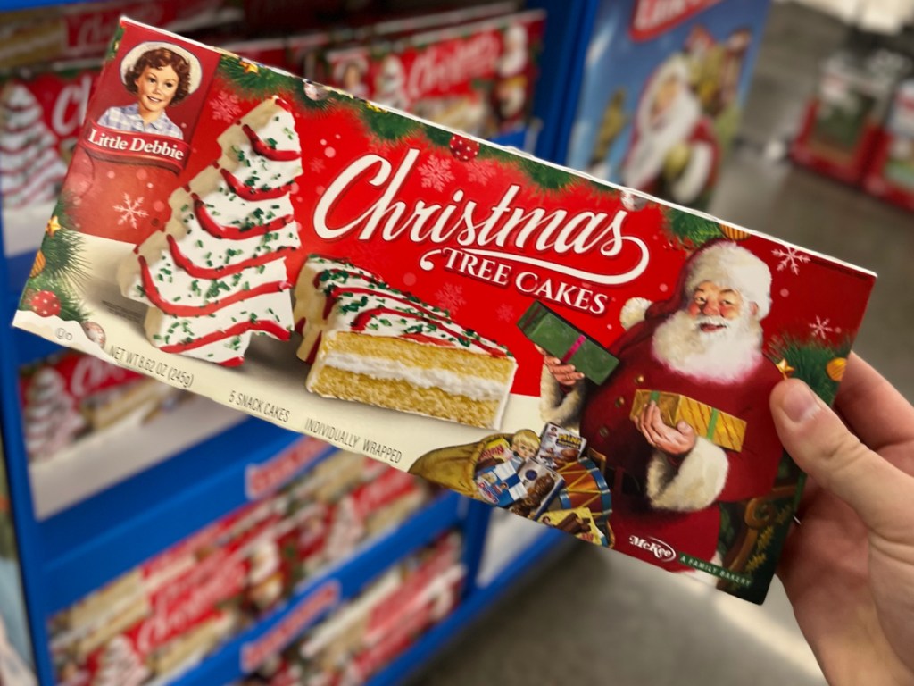 person holding up box if Little Debbie Christmas Tree Cakes