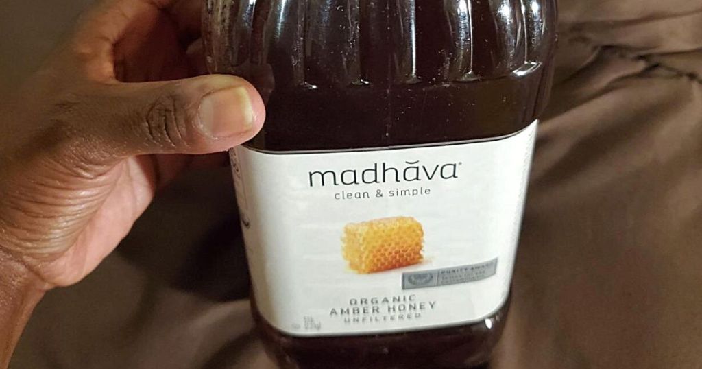 hand holding Madhava organic honey