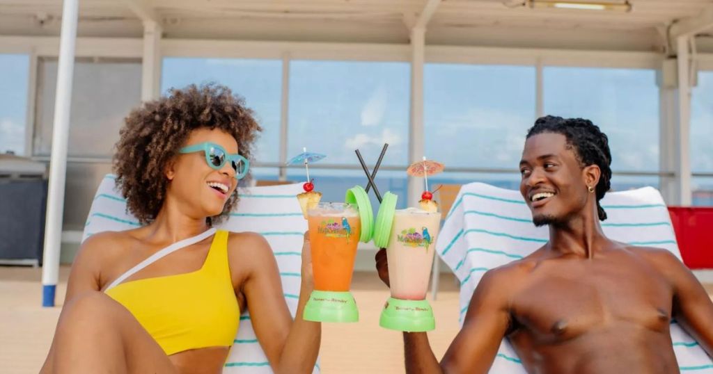 woman and man laying on loungers cheersing margaritas