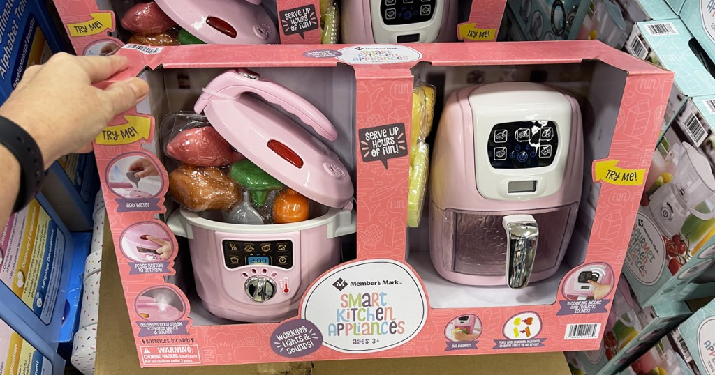 hand holding pink kids kitchen appliance set