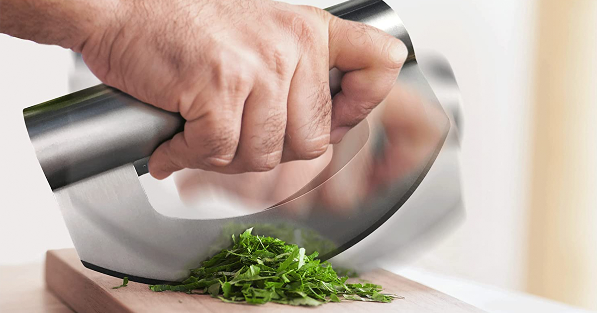 man's hand using a chopper knife to chiffonade herbs