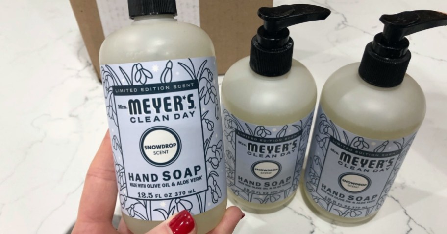 holding a bottle of hand soap