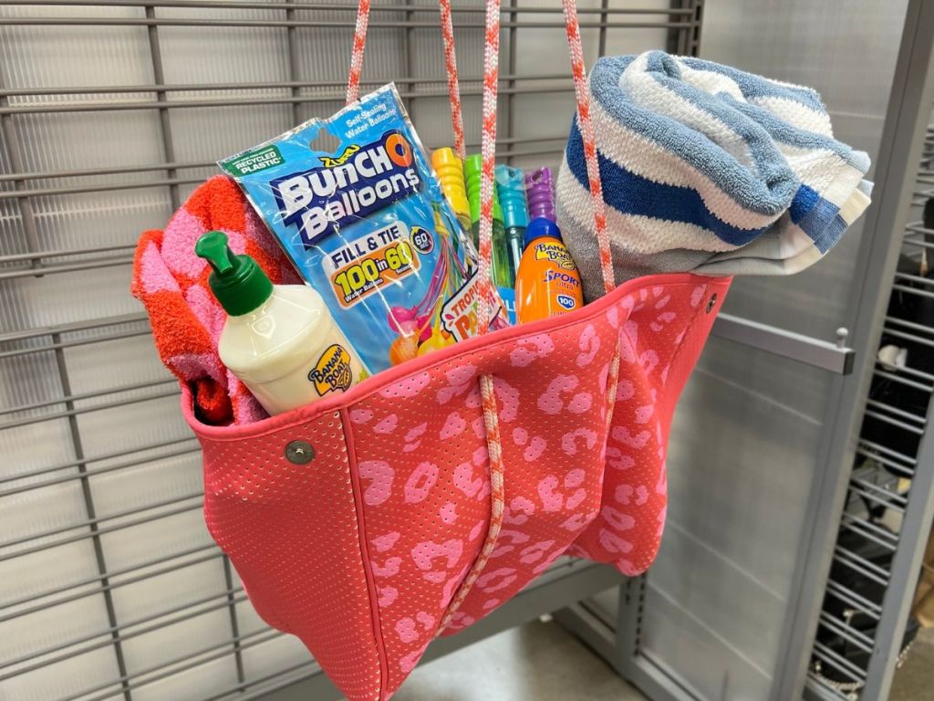 neoprene beach tote stuffed with toys, beach towel, pack of water balloons, bubbles and more.