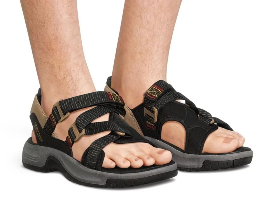 man wearing Ozark Trail Men's Trek Cross Strap Sandals on feet