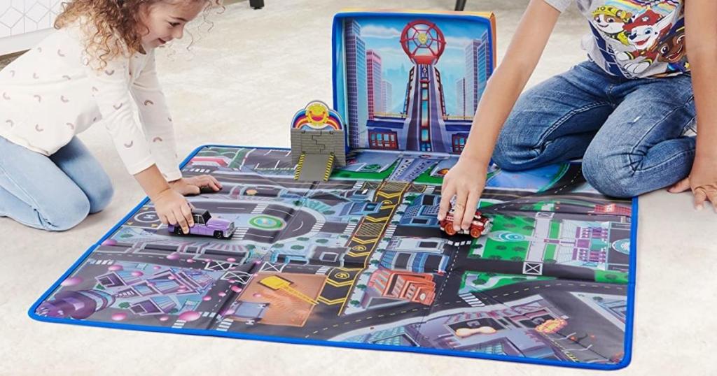 boy and girl playing with the Paw Patrol Adventure City Play Mat while it's unfolded