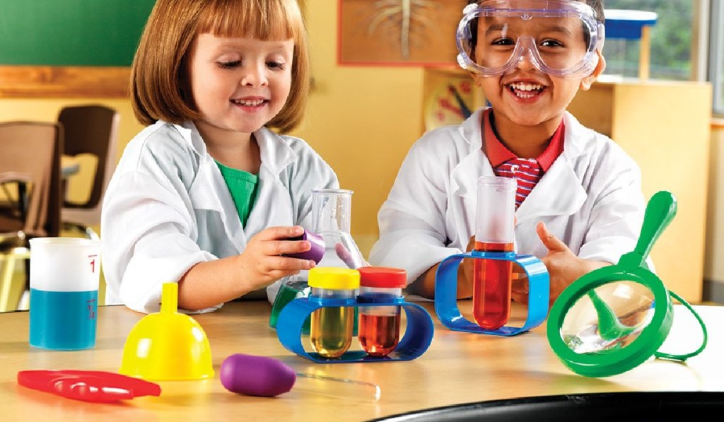 girl and boy playing with science lab set