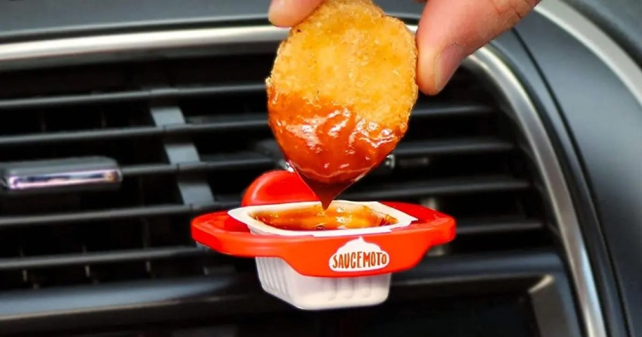 hand dipping a chicken nugget into sauce