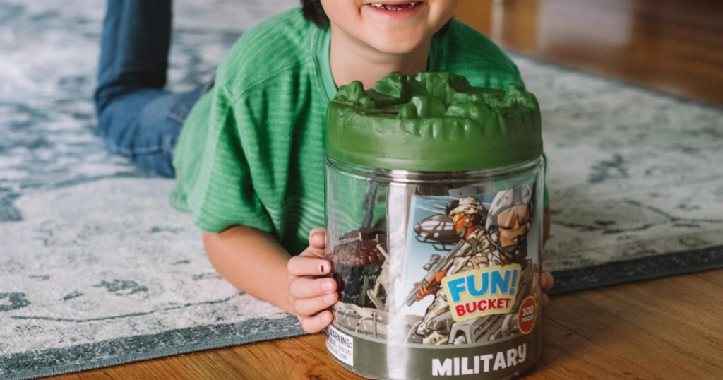 boy smiling holding military figure playset