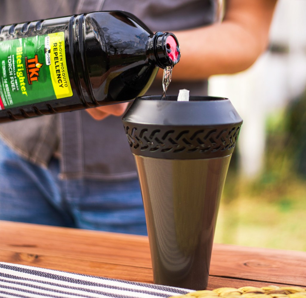 pouring bottle of TIKI Bitefighter Torch Fuel