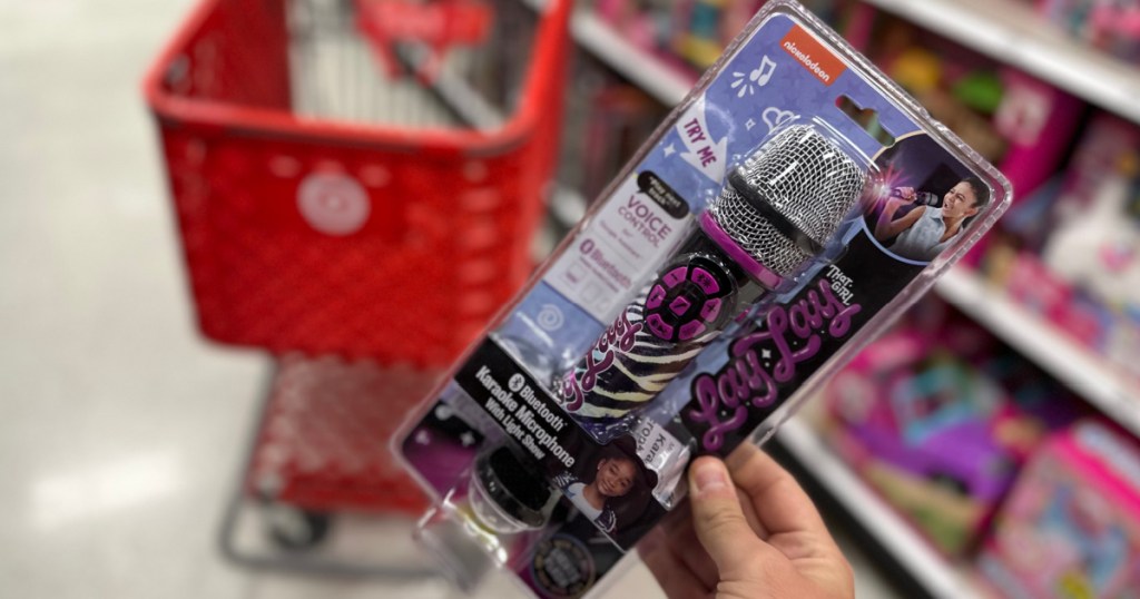 hand holding karaoke microphone in front of red cart